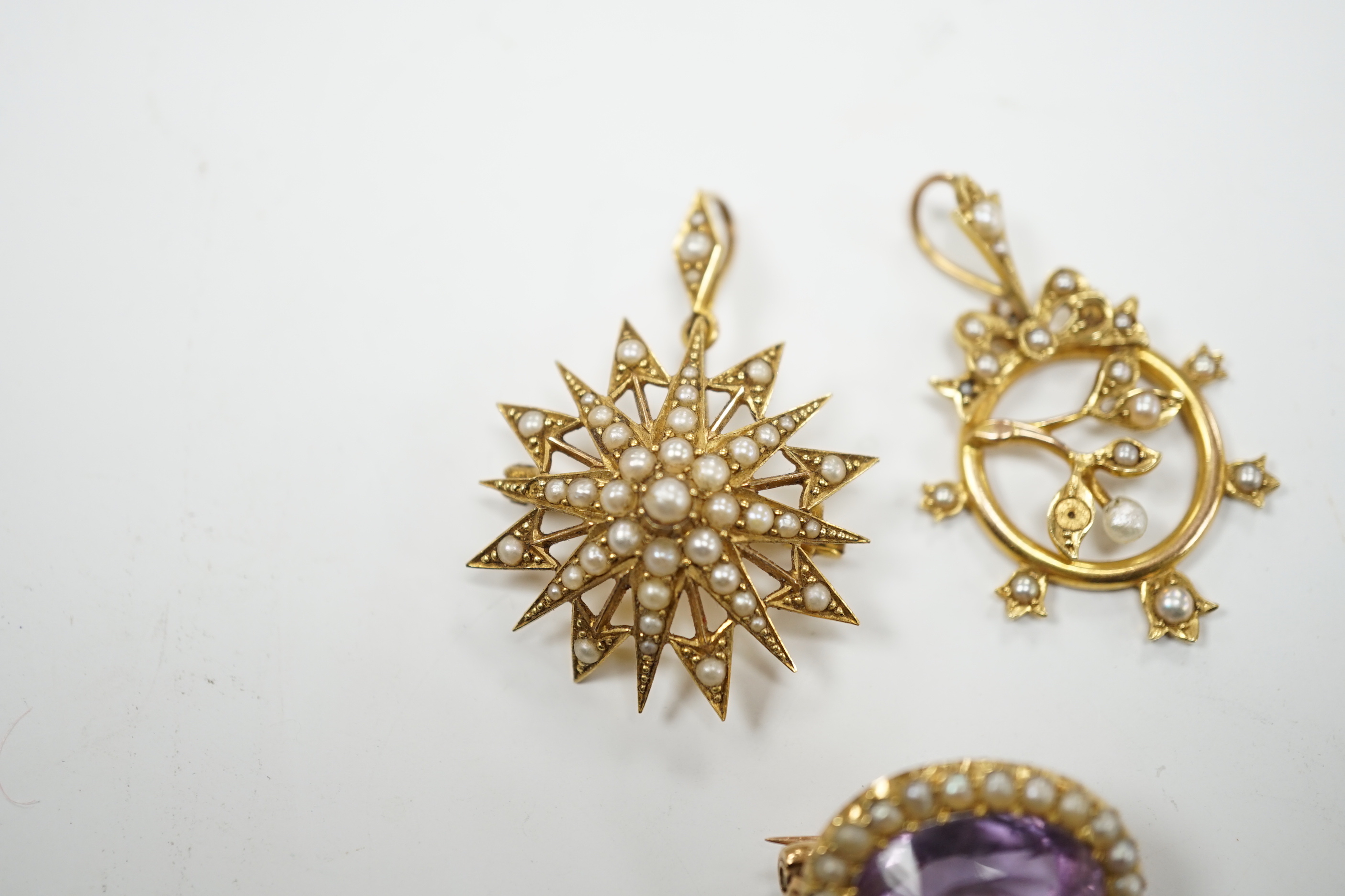 A Victorian 15ct, amethyst and seed pearl foliate pendant and a similar yellow metal and seed pearl set starburst pendant, gross weight 10.6 grams.